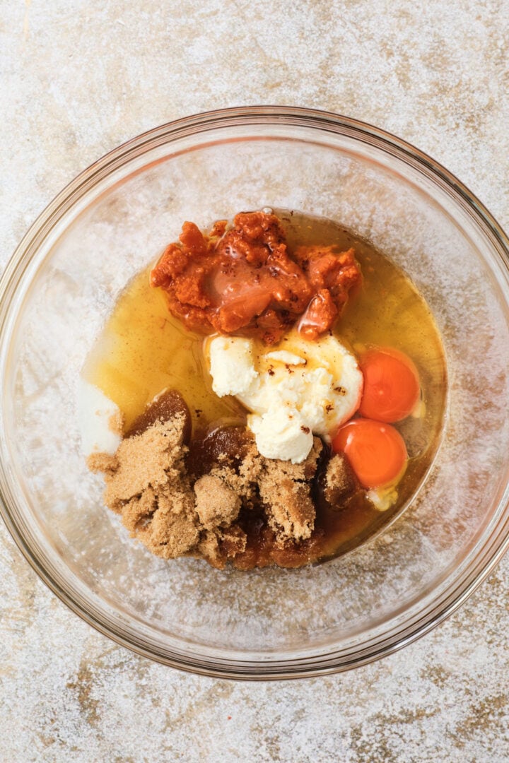 wet ingredients for the pumpkin loaf batter, including pumpkin, eggs, brown butter, oil, brown sugar, ricotta cheese and white sugar.