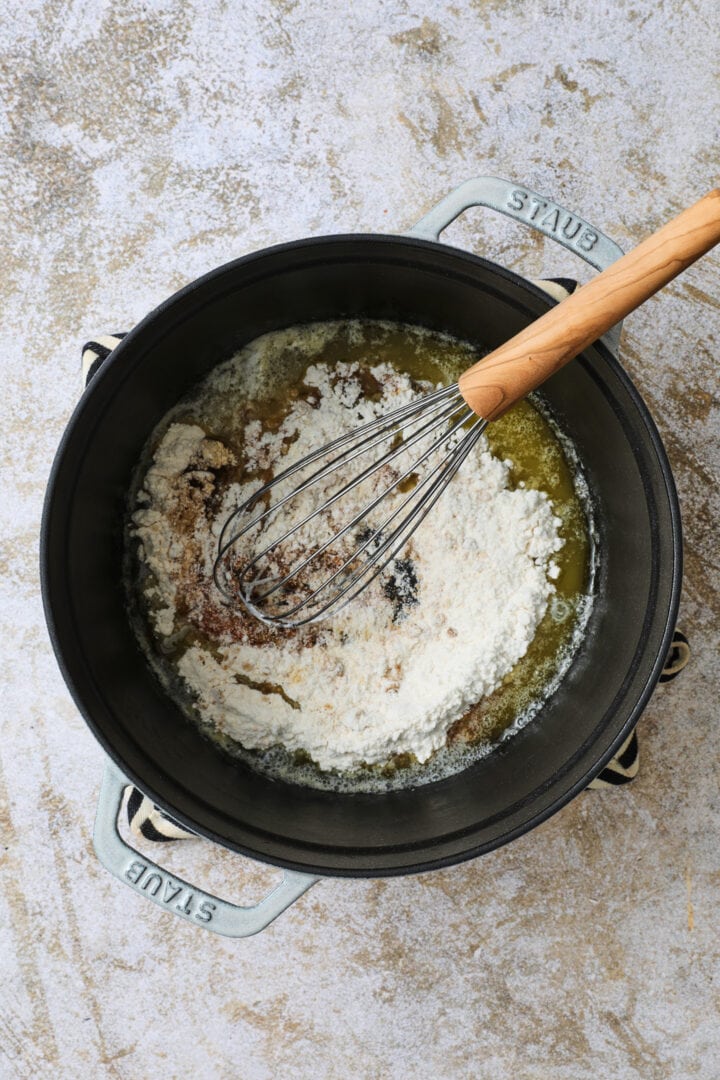 Flour and spices are added to the melted butter to create a roux.