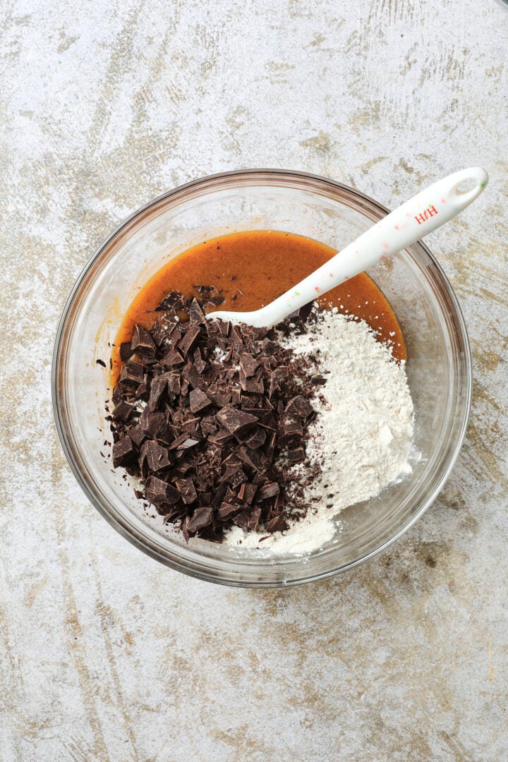 bowl of ingredients for pumpkin chocolate chip cookie dough being folded together.