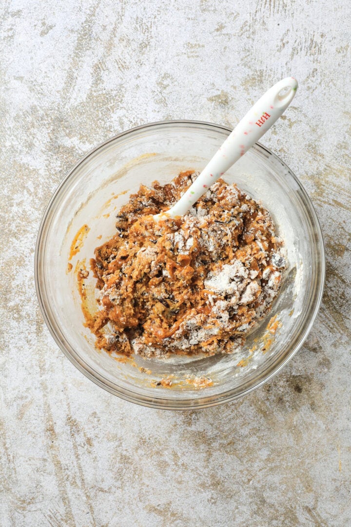 bowl of ingredients for pumpkin chocolate chip cookie dough being folded together.