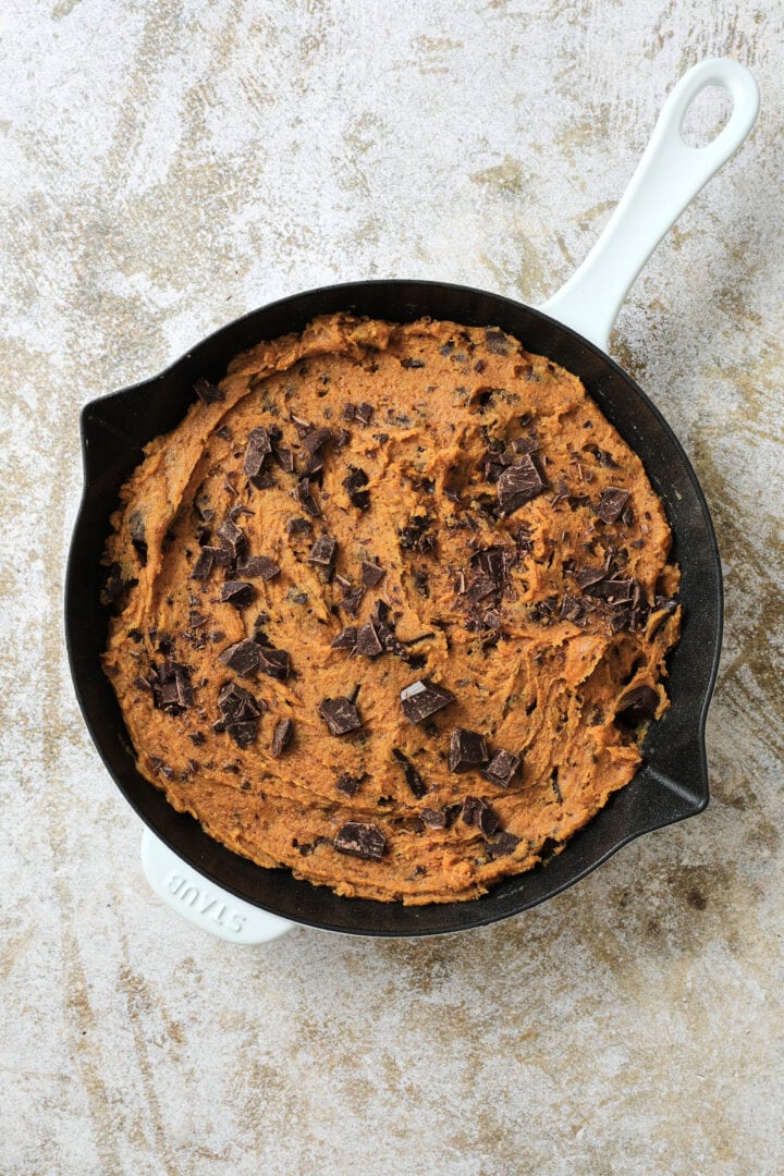 an unbaked pumpkin chocolate chip skillet cookie, ready to go in the oven.