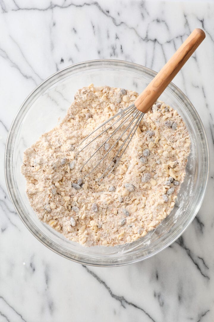 all the dry ingredients needed for brown bread biscuits, mixed together with a whisk in a glass bowl.